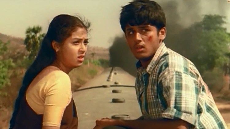 Nithiin and Sada with scared faces. Nithiin wearing a checkered polo shirt while Sada wearing a white and brown shirt in a movie scene from Jayam, a 2002 Indian Telugu-language romantic action drama film.