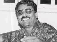 Jayendra Thakur smiling, with a mustache, wearing sunglasses and a polo shirt.