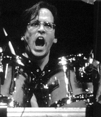 Jeff Porcaro playing drums while his mouth open and wearing eyeglasses