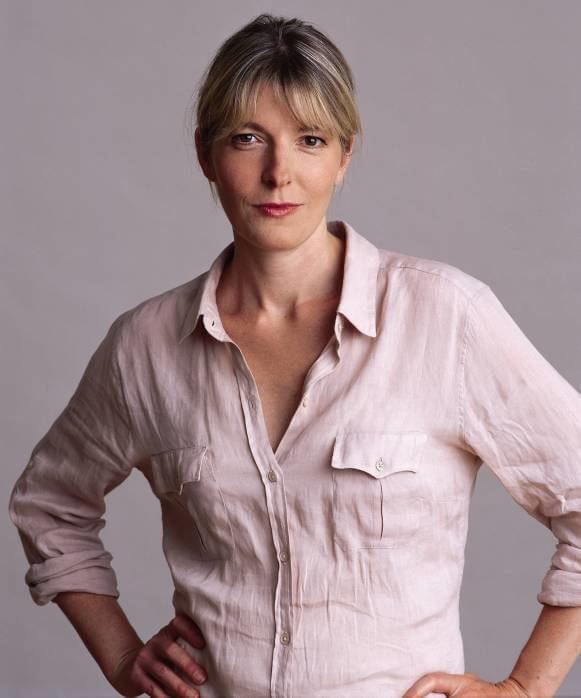 Jemma Redgrave smiling with hands on hips and wearing a pink collared shirt