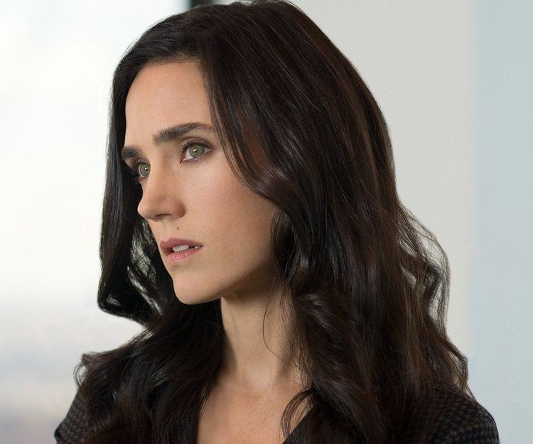 Jennifer Connelly is serious, mouth half open, has long black hair, brown eyes and mole on her left upper lips wearing black dress.