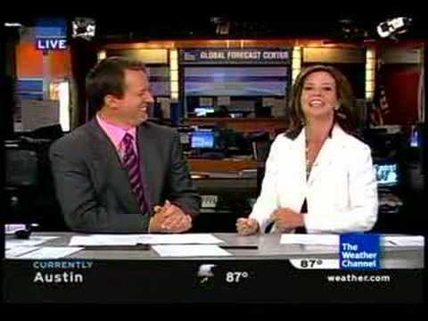 Jennifer Lopez (meteorologist) smiling, wearing a white blazer with a news anchor wearing a suit and a tie.