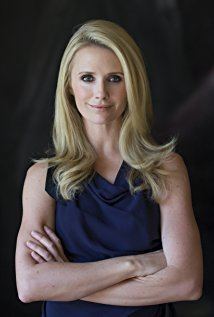 Jennifer Siebel Newsom smiling while her arms crossed and wearing a blue sleeveless blouse