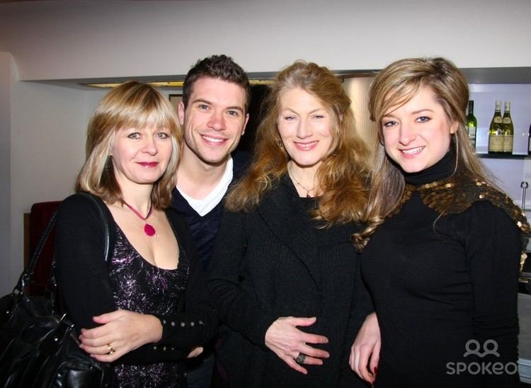 Jenny Funnell with blonde hair, wearing a black dress and carrying a black bag together with a man wearing a black shirt and two ladies both wearing a black dress.