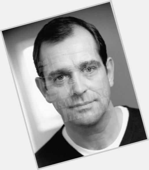 Jeremy Gittins with a tight-lipped smile while wearing a black and white shirt