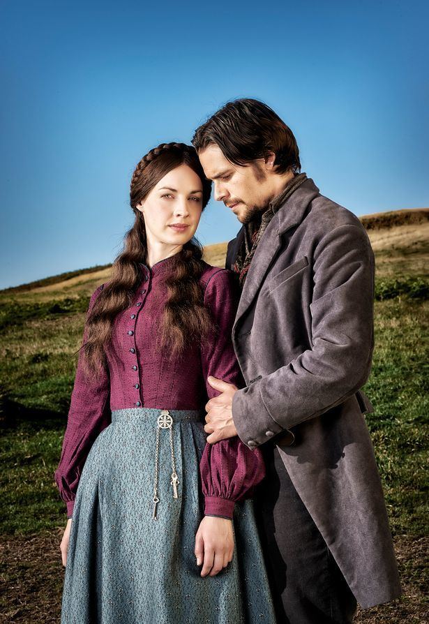 Jessica Raine posing with Hans Matheson while standing close to each other in the 2016 period drama series Jericho