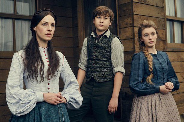 Jessica Raine posing while wearing a white and red blouse, Sam Bottomley wearing a vest and long sleeves, and Amy James-Kelly wearing a blue blouse