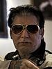 Jesco White looking serious while wearing a white and black sleeves and shades