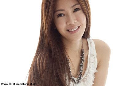 Jesseca Liu smiles while wearing a white sleeveless shirt and a necklace
