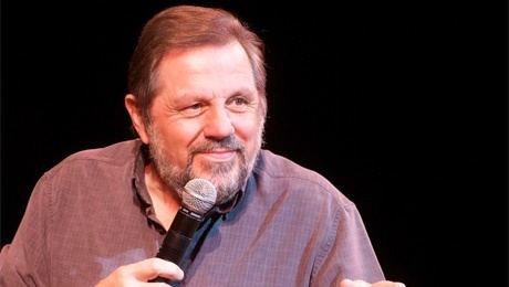 Jethro smiling while holding the microphone and wearing a black t-shirt