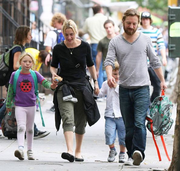 Jim Threapleton and Kate Winslet with their children walking on the street.