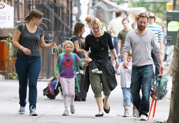 Jim Threapleton and Kate Winslet with their children walking on the street.