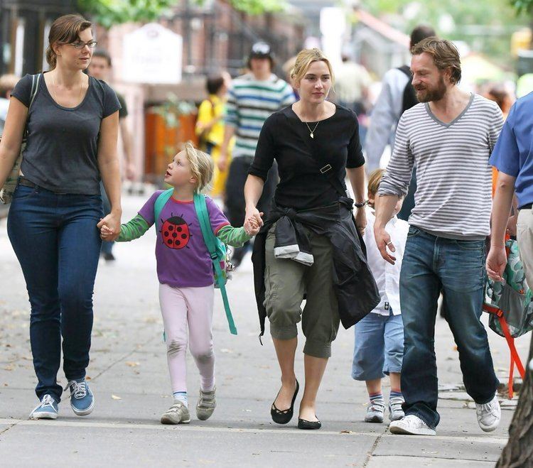 Jim Threapleton and Kate Winslet with their children walking on the street.