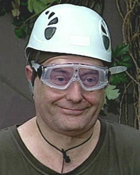 Jimmy White smiling, wearing a white protective hat, protective eyeglasses, and a green shirt.