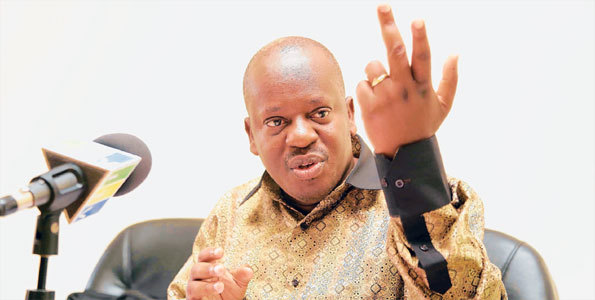 Job Ndugai speaking with hand gestures while wearing a black and brown long sleeves