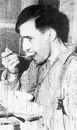 Joe Arridy eating food served in prison and wearing striped prison clothing.