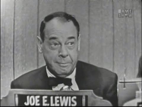 Joe E. Lewis looking at something while wearing a coat, long sleeve, and bow tie