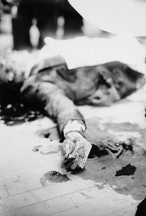 Joe Masseria laying on the floor after being shot to death on April 15, 1931 with a card still on his hand.