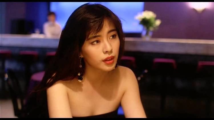 Joey Wong as Lap talking to someone inside a night club and wearing a black strapless shirt in a scene from My Heart Is That Eternal Rose, 1989.