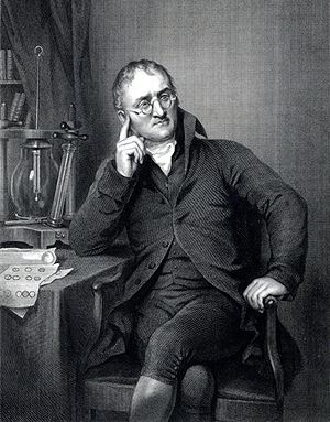 A sketch of John Dalton looking serious with his finger pointing into his head, with eyeglasses, sitting on a chair and arms leaning on the table, with an apparatus on his back, wearing a scarf under a black coat, and pants