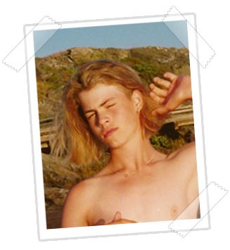 John Hron with blonde shoulder-length hair is dazzled by the sunlight