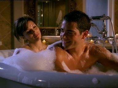 Eva Longoria rubbing the back of Jesse Metcalfe during a bathtub scene in the TV series "The Desperate Housewives"