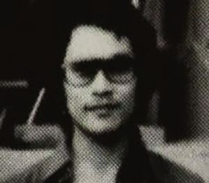 Joji Obara smirks while wearing pair of eyeglasses