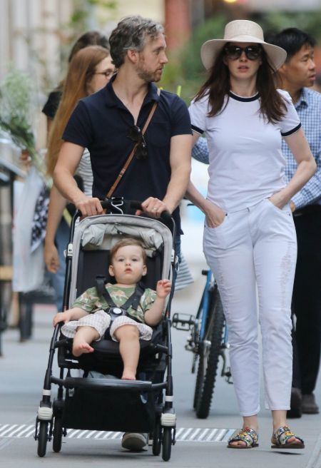 Jonathan Rosebanks Shulman with his parents Anne Hathaway and Adam Shulman walking down the street while Jonathan is on his stroller