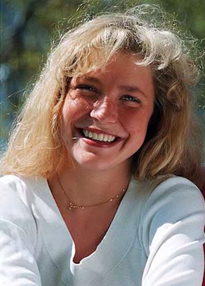 Jonna Liljendahl smiling while wearing a white blouse and gold necklace