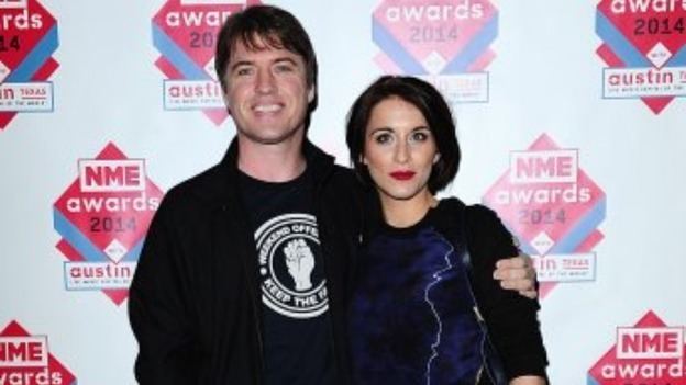 Jonny Owen wearing black jacket and t-shirt and Vicky Mcclure in her black ang blue outfit at The NME Awards 2014 held at O2 Academy Brixton