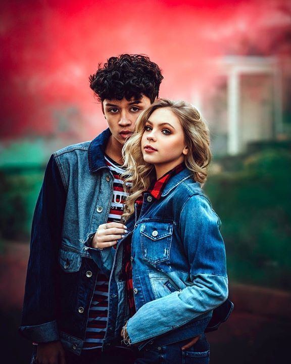 Jordyn Jones and Brandon Westenberg with a fierce look while Jordyn is wearing a denim jacket and black and red checkered blouse