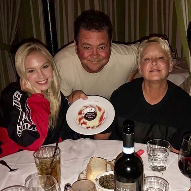 Jordyn Jones is with her father Tim, and her mother Kelly Jones while they are smiling and her father is holding a plate with cake