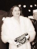 Josephine Wayne in her white dress while holding her purse
