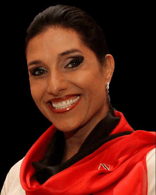 Jowelle de Souza smiling with a black background, wearing a white blouse, a black and orange scarf around her neck with the printed letter "N" and silver earrings