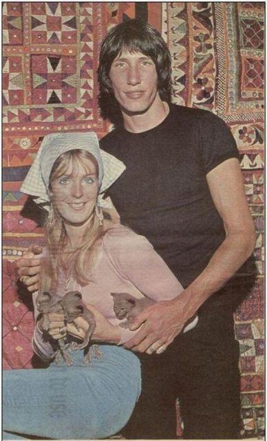 Judith Trim smiling while carrying kittens and Roger Waters at his side wearing a black shirt and black pants