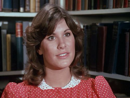 Judy Norton wearing a polka dots red dress with white collar.