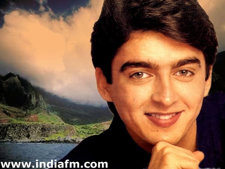 Jugal Hansraj smiling while his hand on his chin and wearing black long sleeves