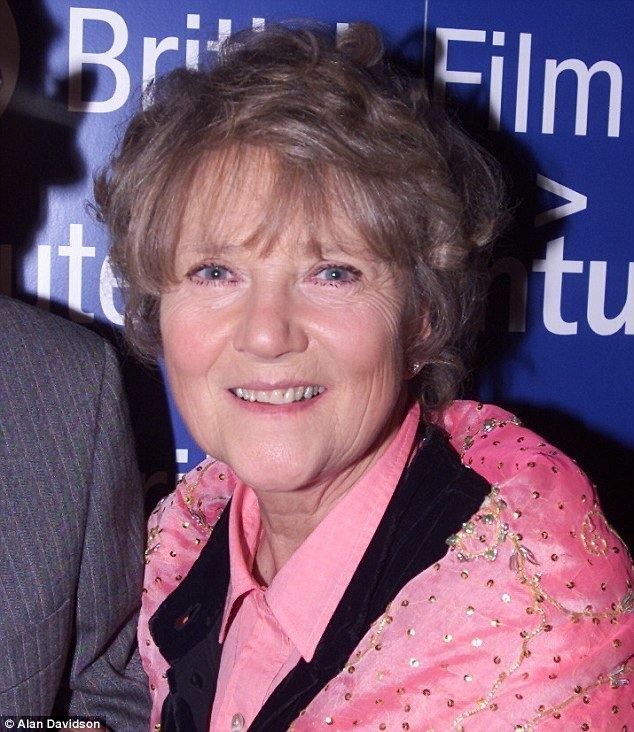 Julia Foster smiling while wearing a pink and black sequin blouse