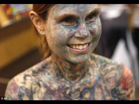 Julia Gnuse wearing earrings and covered her body with tattoos.