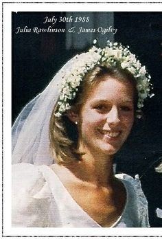 Julia Ogilvy smiling, wearing a flower headdress, a white veil, and a white gown.