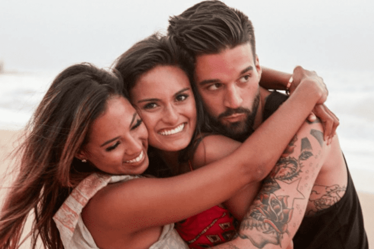 Julia Rose is at the center, Mikala Thomas is on the left, and Stephen is on the right, embracing each other during the "Are You The One" reality TV show.