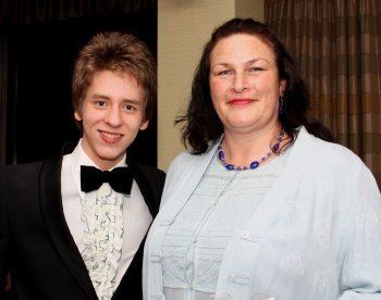 Julie T. Wallace smiling while wearing light blue blouse with Ciaran Brown who is wearing black coat, white long sleeves and bow tie