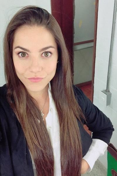 Juliette Pardau smiling with her long hair down and wearing a white and black blouse