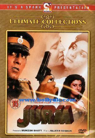 Vinod Khanna (left) holding a gun, with a serious face, and wearing a black and yellow peaked cap and brown police inspector uniform. Vinod looking at Meenakshi Sheshadri with a serious face (upper right). Sangeeta Bijlani with a fierce look and black wavy hair is wearing a gold tube top and necklace on the DVD cover of the 1990 Indian Hindi-language action film, Jurm
