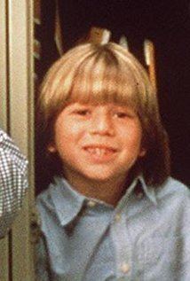 Justin Cooper smiling, with blonde hair and wearing a blue polo shirt.