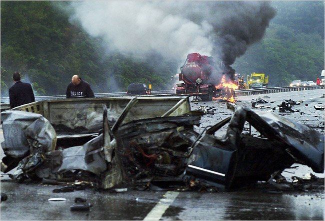 The destroyed tank truck and Justin Strzelczyk's car with two men at the back and fire in the middle of the road near the red truck