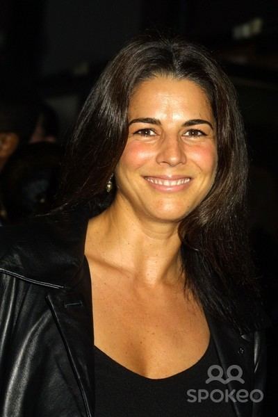 Justine Miceli smiling while wearing a black leather jacket and black inner top