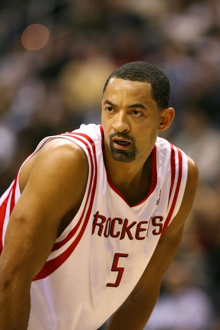 Juwan Howard looking serious with a beard and mustache while wearing a red and white jersey with the word "ROCKETS" and jersey number "5" written on it