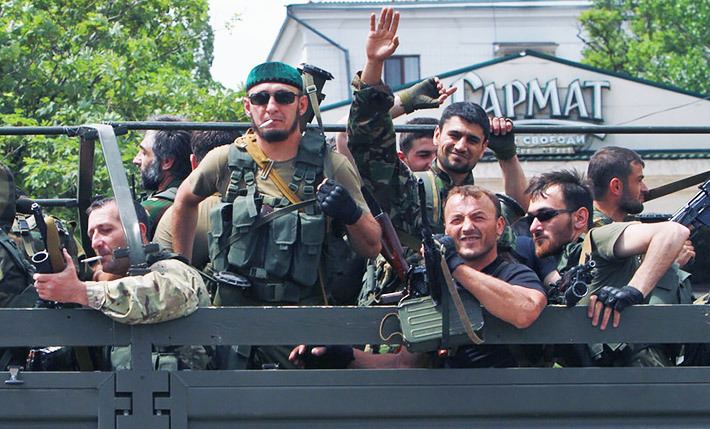 A group of armed Kadyrovtsy men riding a military elf