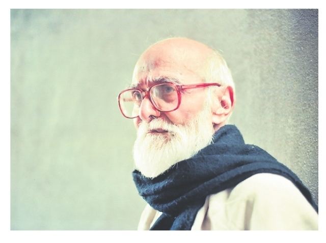 Kaloji Narayana Rao looking serious with his mustache and long beard while wearing a white shirt, blue scarf and eyeglasses